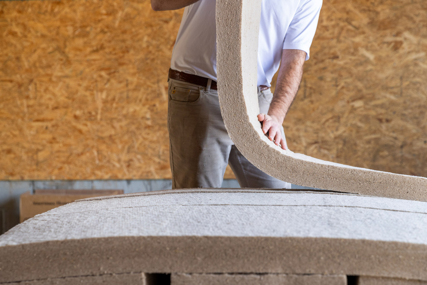 Man picking up a batt of insulation